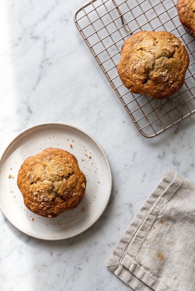 A single banana muffin in a mug fresh out of the microwave