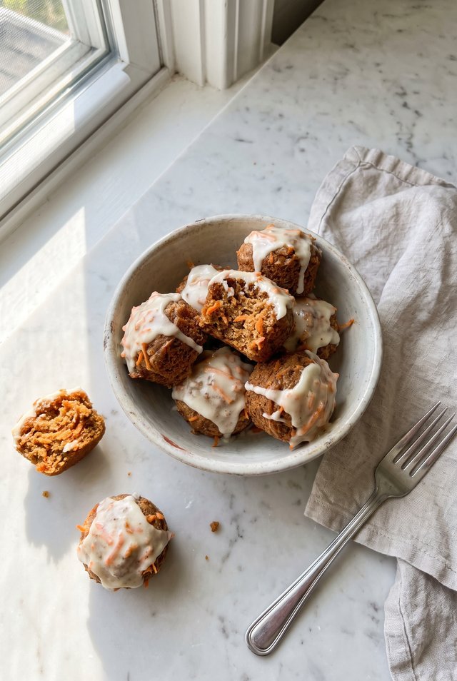 Carrot cake energy bites coated in shredded coconut with grated carrot visible