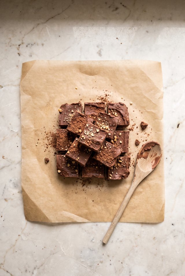 Squares of chocolate protein fudge stacked on a plate
