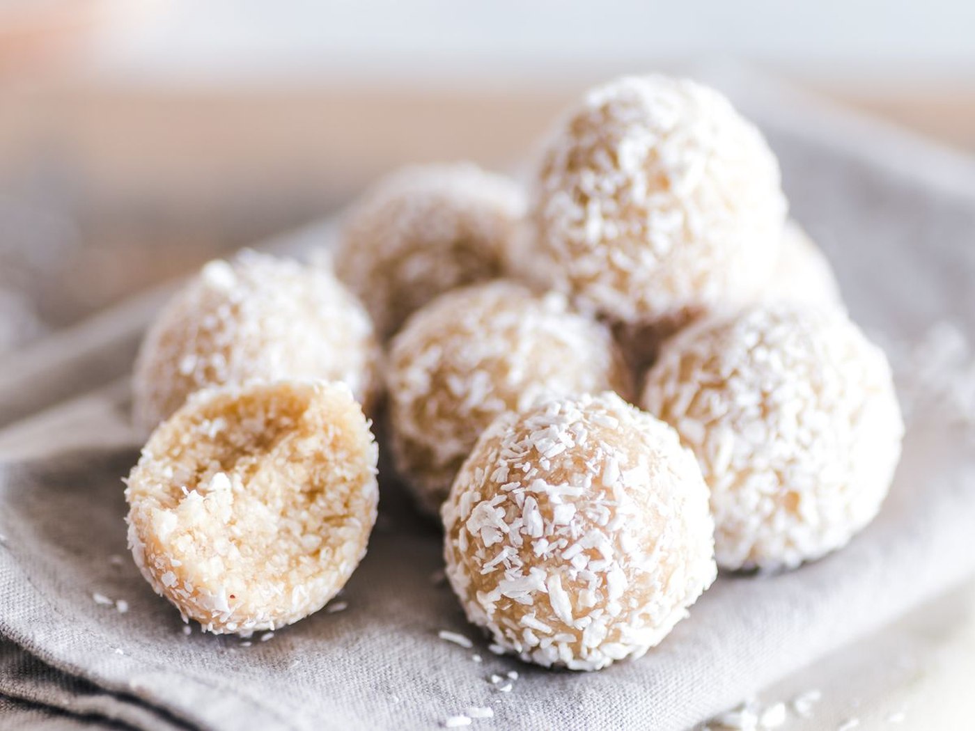 Coconut fat bombs on a small plate with a bite taken out of one