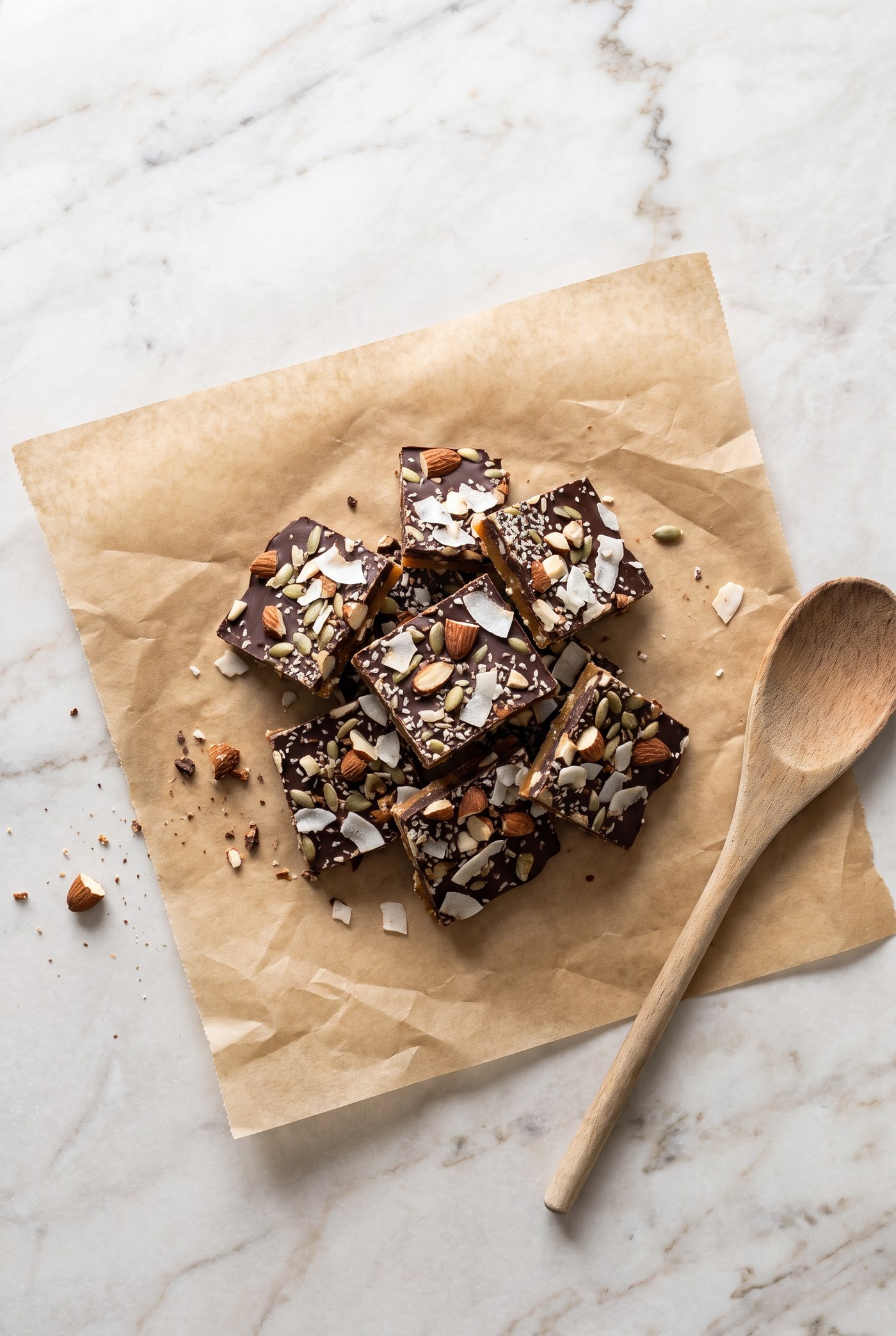 Broken pieces of homemade toffee with toasted almonds and a chocolate drizzle