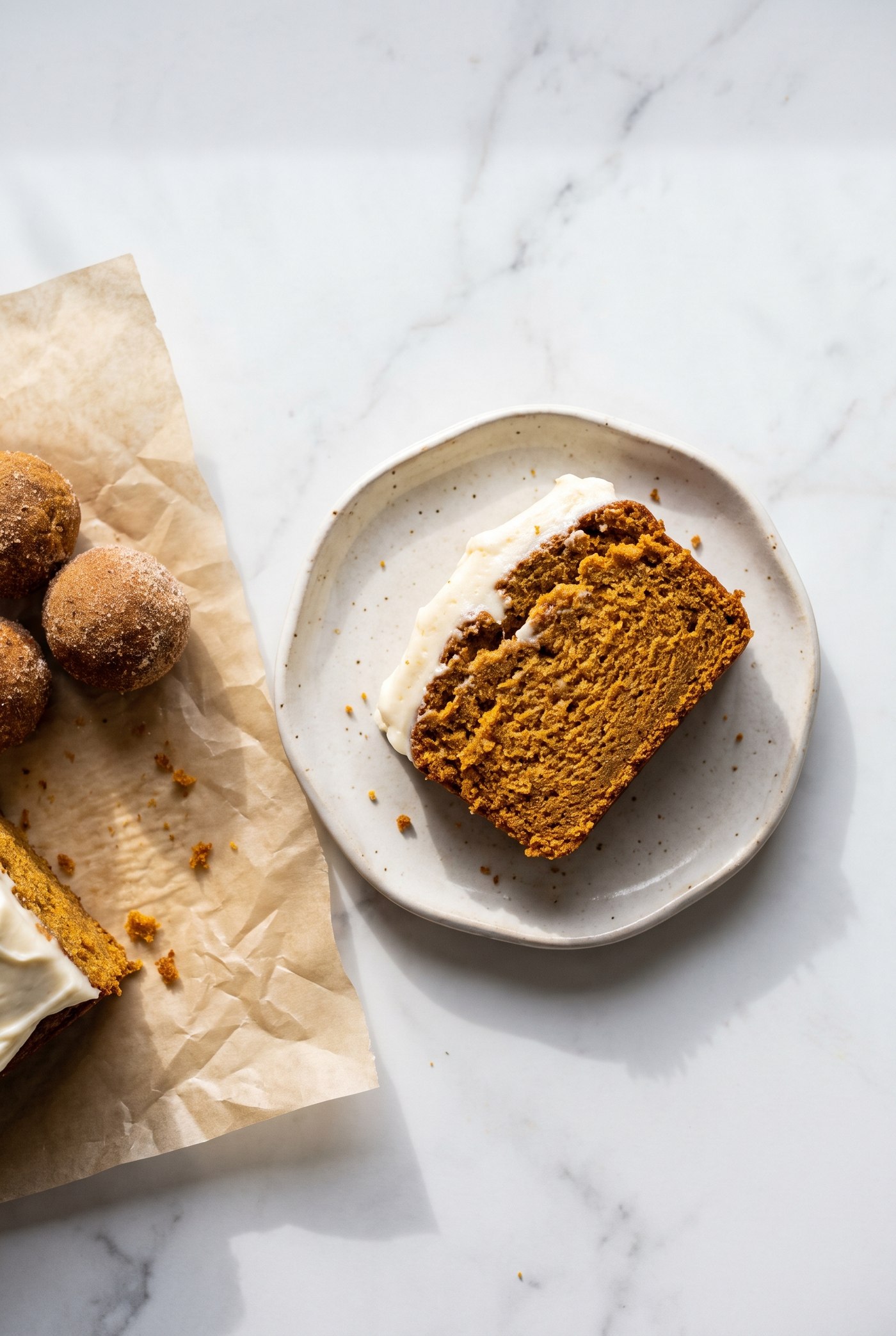Squares of pumpkin spice snack cake on a plate with a fall-spiced crumb