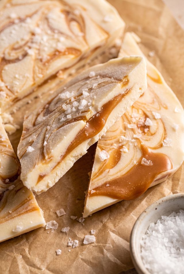 Broken shards of salted caramel yogurt bark with caramel ribbons swirled through the yogurt and flaky sea salt on top